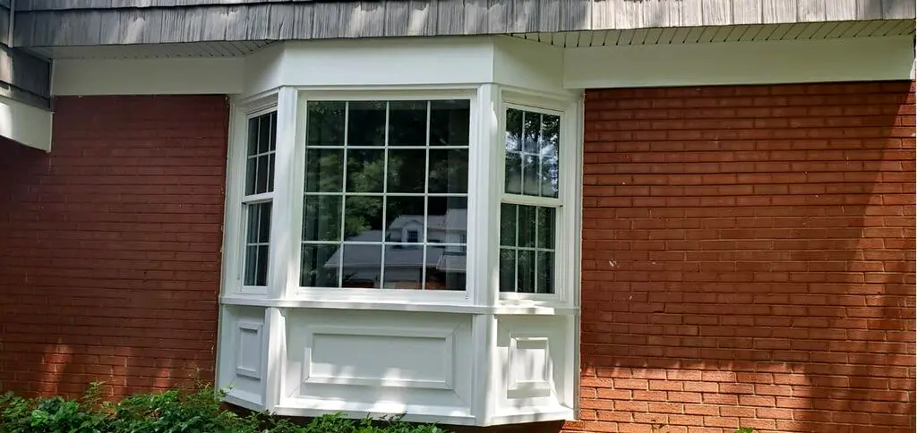 Clean red brick and white bay window trim after exterior washing