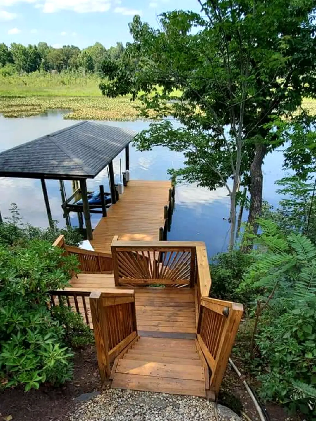 After: The same boat dock stairs, landing and pier after cleaning and staining, in a warm wood tone