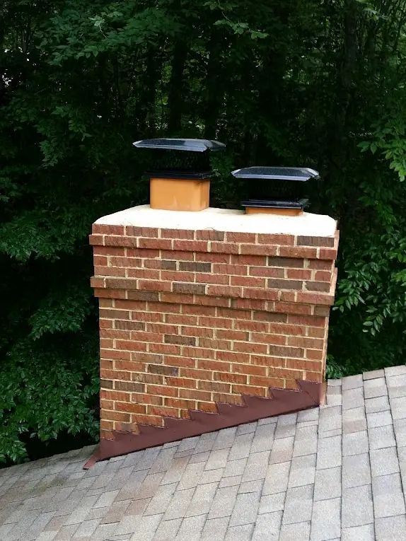 Brick chimney on a shingle roof after cleaning