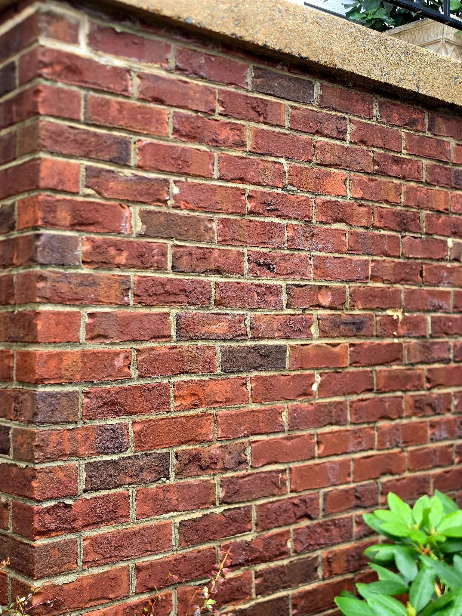 After: The brick wall of the same stoop after cleaning, with even red brick and clean mortar joints