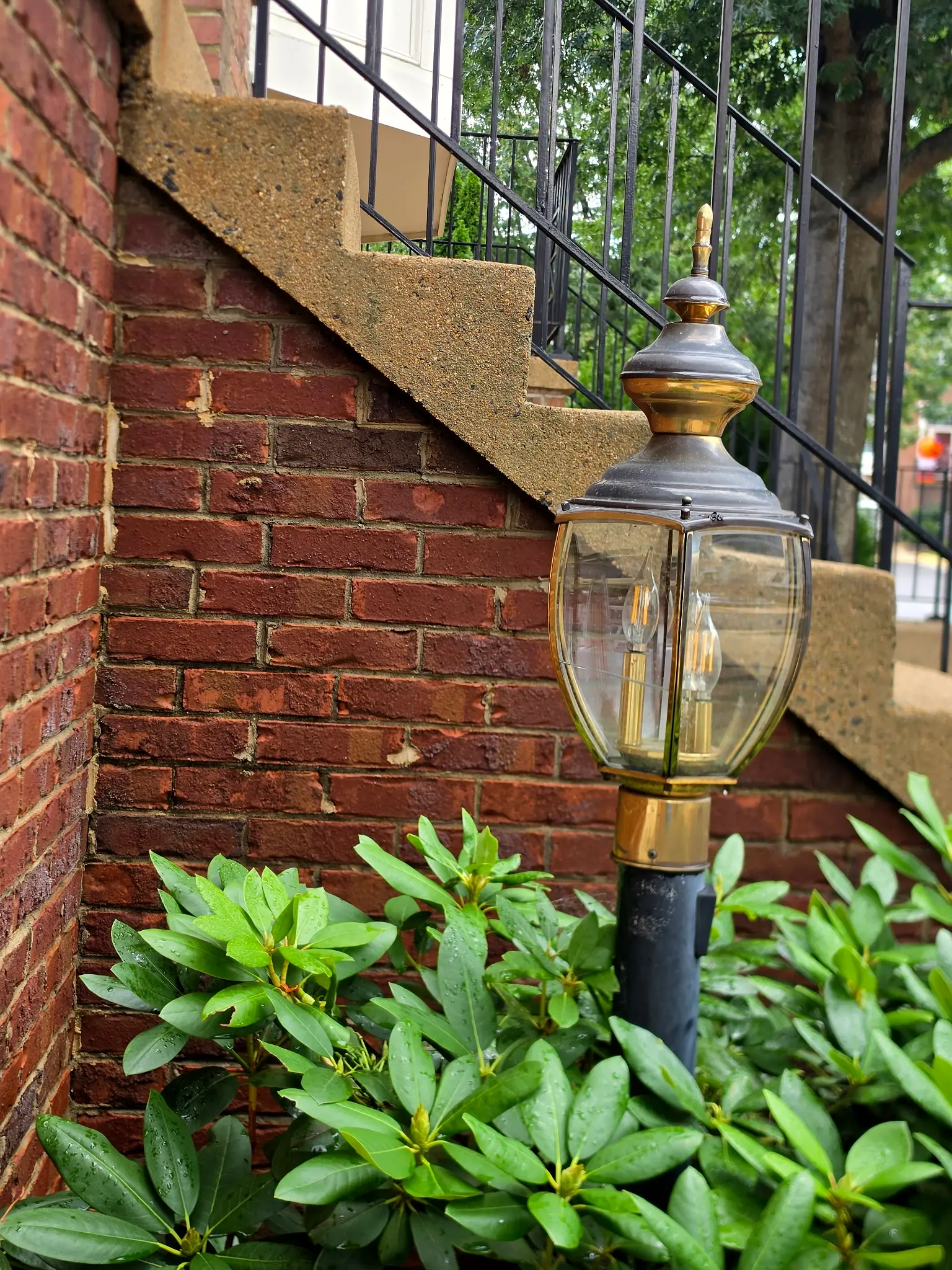 After: The same brick wall beside the lamp post after cleaning, with the red brick color restored