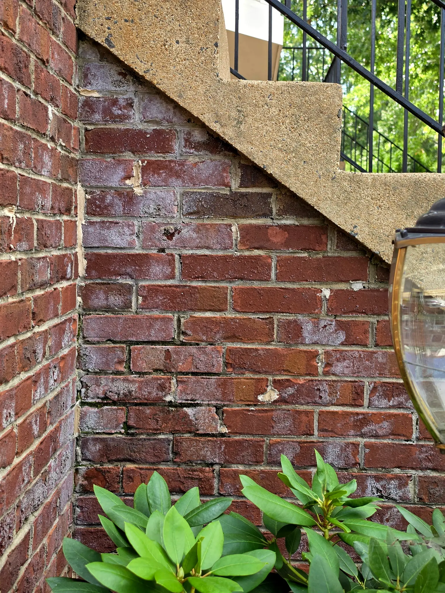 Before: Red brick wall under exposed-aggregate front steps, covered in a chalky white haze