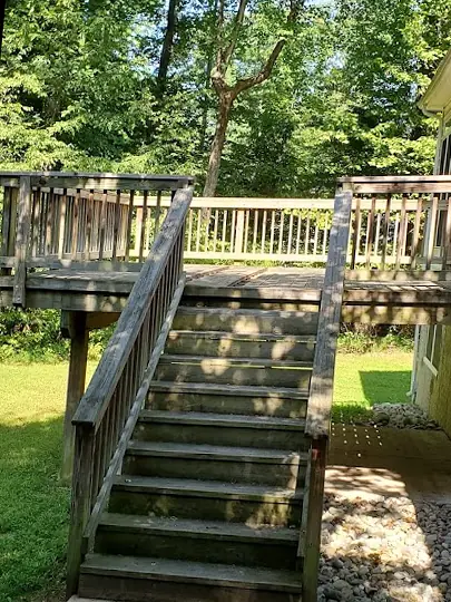 Before: Weathered gray deck stairs and railings stained dark by mildew
