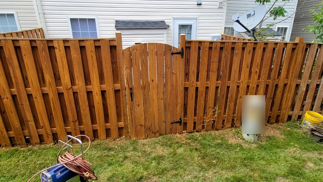 Wood privacy fence and arched gate freshly cleaned and stained