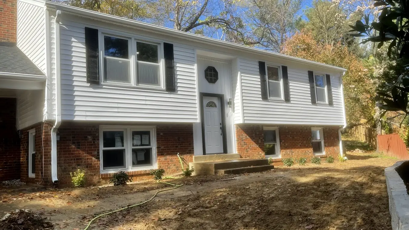 Raised-ranch home with bright white vinyl siding and red brick after washing
