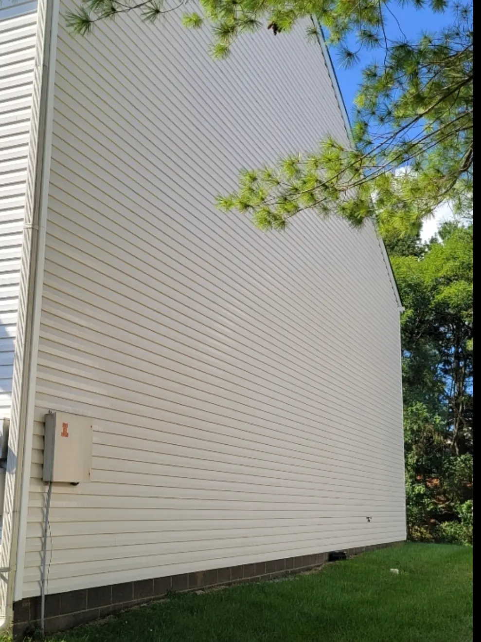 After: The same gable wall after soft washing, with the siding back to an even off-white