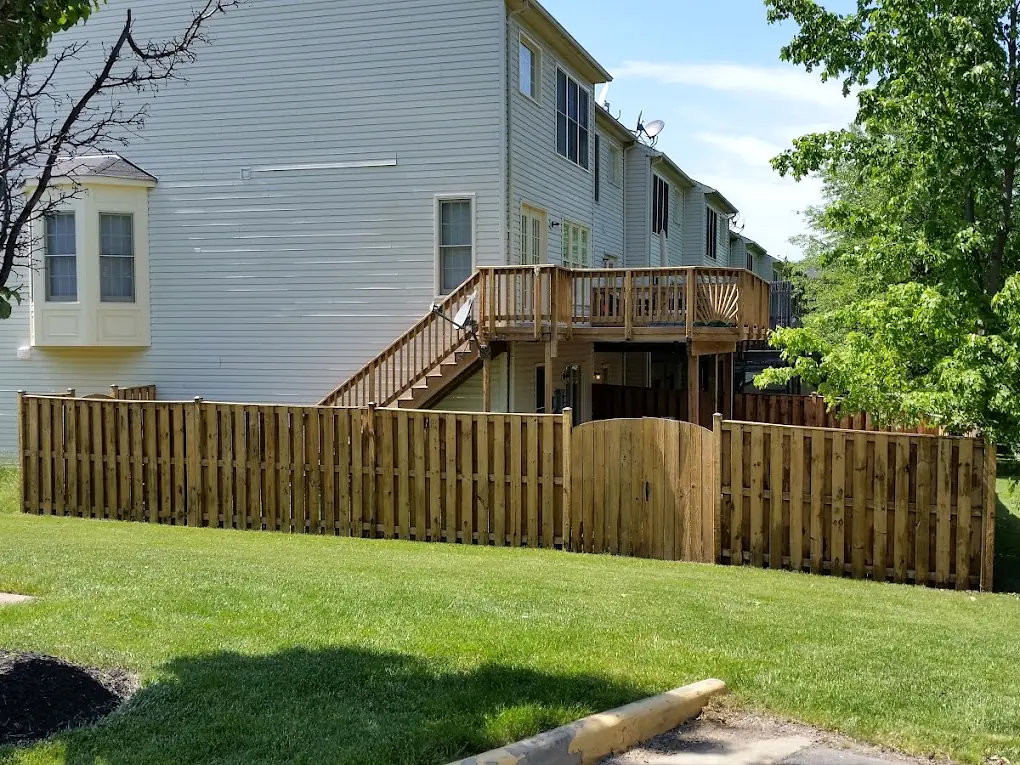 After: The same townhouse fence and deck after cleaning and staining, now a warm cedar tone