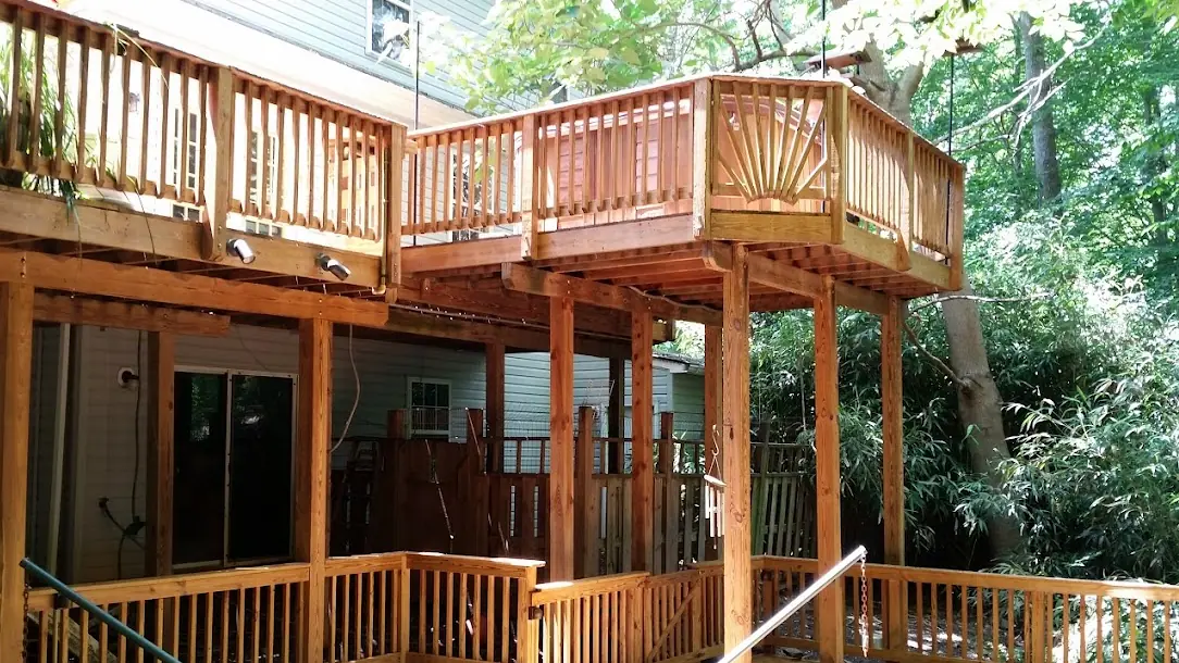 After: The same two-level deck after cleaning and staining, in a warm wood tone